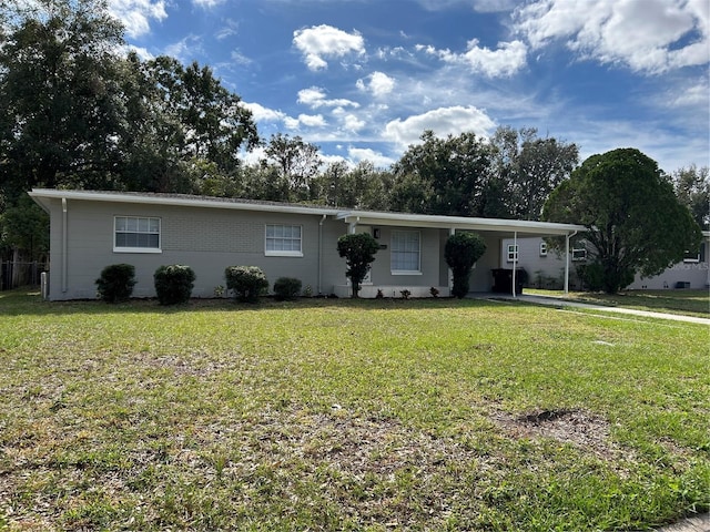 single story home featuring a front lawn and a carport