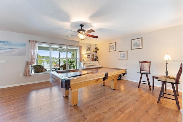 game room with ceiling fan, a textured ceiling, billiards, and light hardwood / wood-style flooring