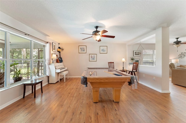 recreation room featuring ceiling fan, light wood-type flooring, a textured ceiling, and pool table