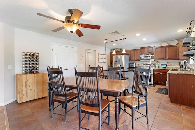 dining area with ceiling fan, sink, light tile patterned floors, and track lighting