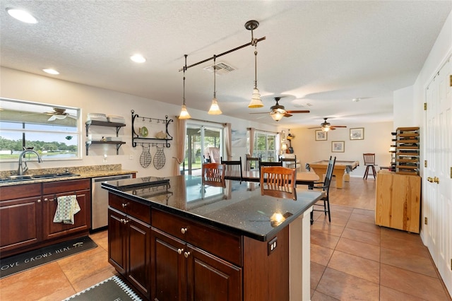 kitchen with sink, a center island, stainless steel dishwasher, decorative light fixtures, and light tile patterned floors