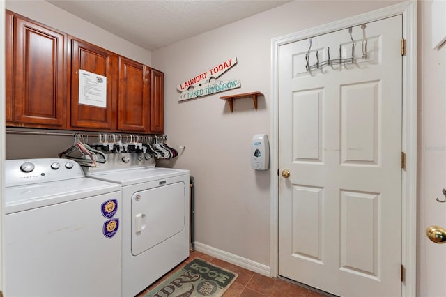 laundry area featuring washing machine and clothes dryer, tile patterned floors, cabinets, and a textured ceiling