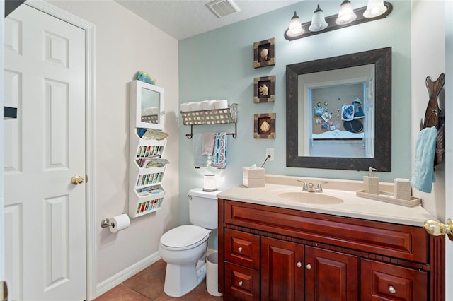 bathroom featuring tile patterned floors, vanity, toilet, and a textured ceiling