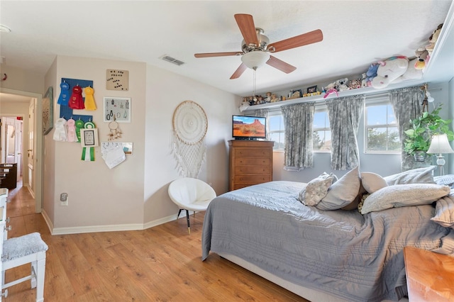 bedroom featuring multiple windows, light wood-type flooring, and ceiling fan