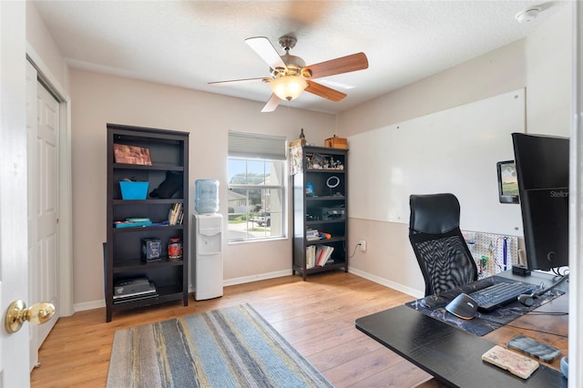 office area with ceiling fan, light hardwood / wood-style floors, and a textured ceiling