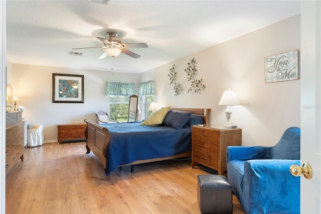 bedroom featuring ceiling fan, a textured ceiling, and light wood-type flooring