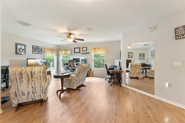 living room featuring ceiling fan, a healthy amount of sunlight, and a textured ceiling