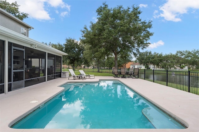 view of swimming pool featuring a sunroom, a yard, and a patio