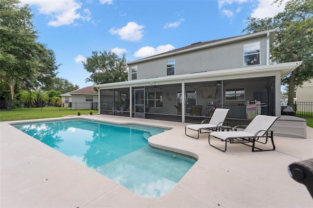 view of swimming pool featuring a sunroom, ceiling fan, a patio area, and a yard