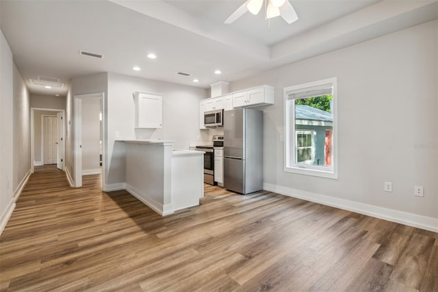 kitchen featuring white cabinets, ceiling fan, light wood-type flooring, and appliances with stainless steel finishes