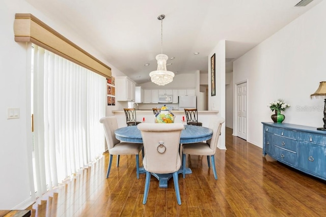 dining room featuring dark hardwood / wood-style flooring and an inviting chandelier