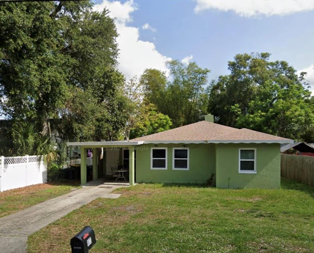 ranch-style home with a front yard and a carport