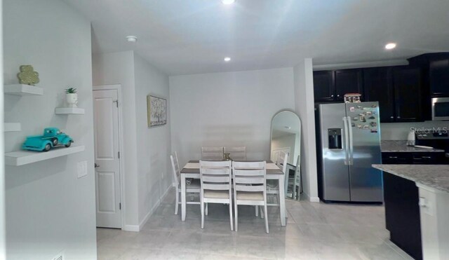 kitchen with light stone countertops, appliances with stainless steel finishes, and light tile patterned floors