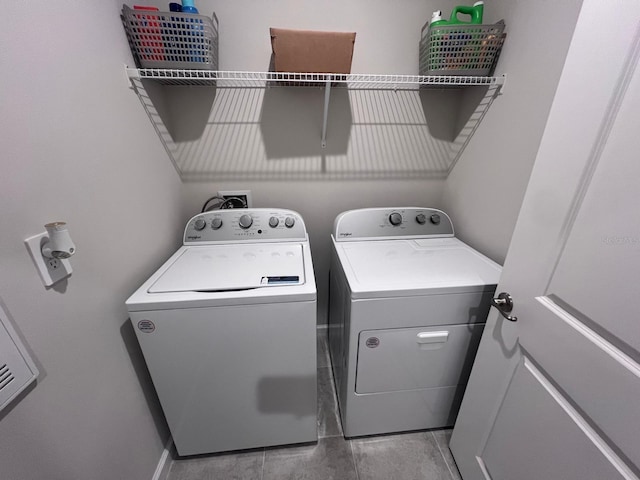 laundry area with light tile patterned floors and washing machine and dryer