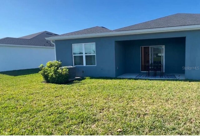 back of property featuring a lawn and a patio area