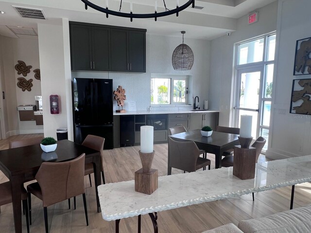 dining room featuring light hardwood / wood-style flooring, sink, and an inviting chandelier