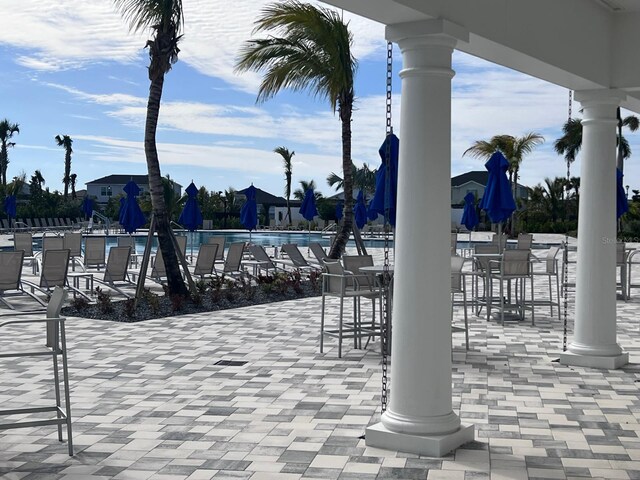 view of patio with a bar and a community pool