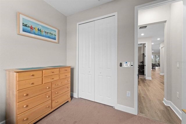 bedroom with light carpet and a closet