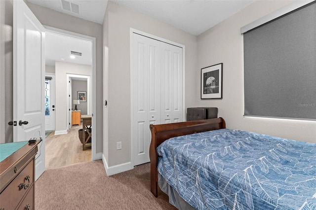 bedroom featuring light carpet and a closet