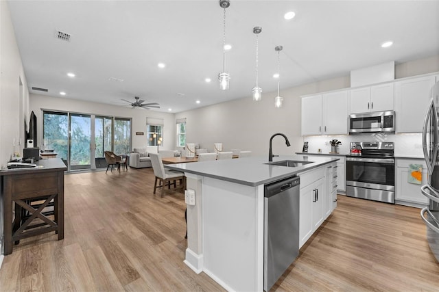 kitchen featuring white cabinets, sink, an island with sink, and appliances with stainless steel finishes