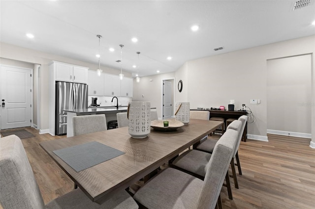 dining room with hardwood / wood-style floors and sink