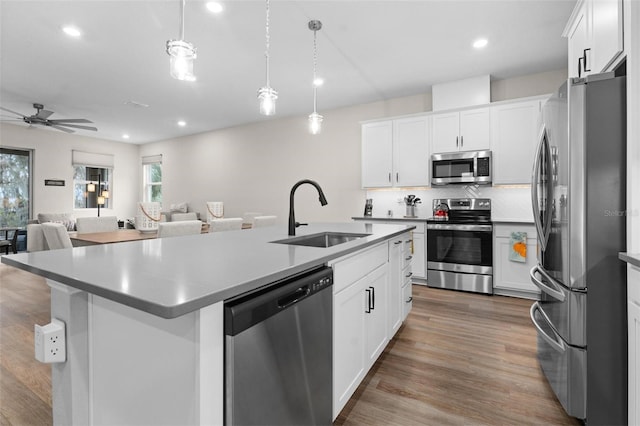 kitchen featuring a center island with sink, sink, white cabinetry, and stainless steel appliances