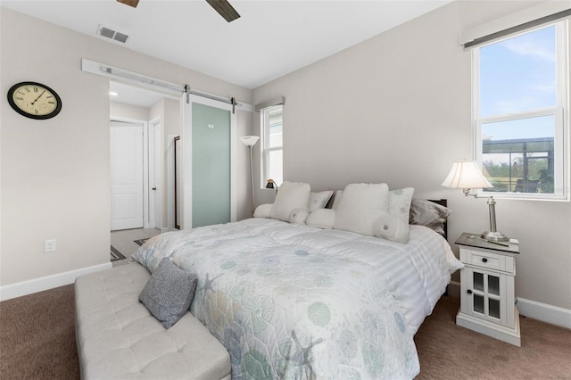 bedroom featuring a barn door, ceiling fan, and carpet