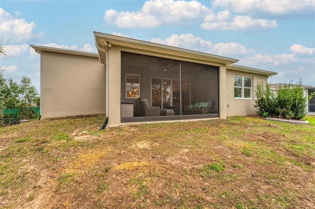 rear view of house featuring a lawn, a sunroom, and ceiling fan