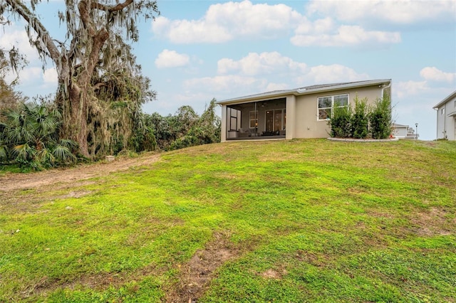 back of house with a sunroom and a yard