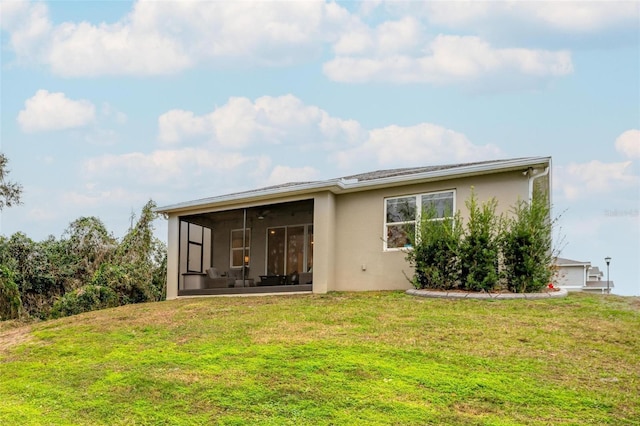 rear view of property featuring a sunroom and a yard