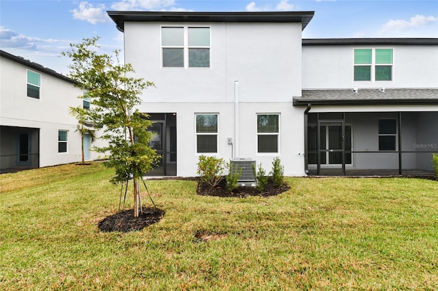 back of property featuring cooling unit and a yard