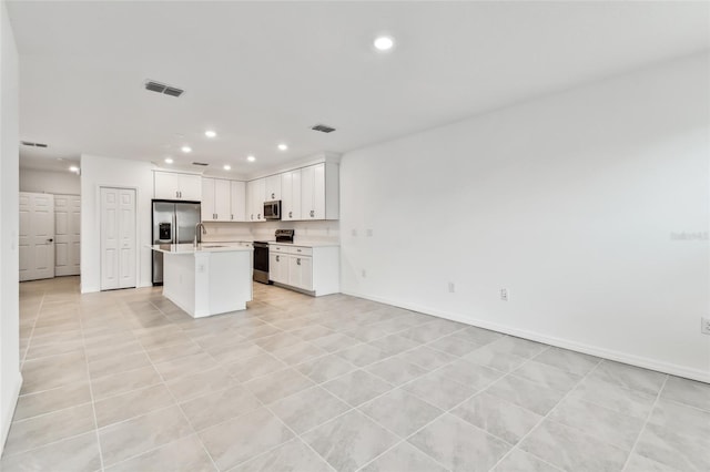 kitchen with white cabinetry, appliances with stainless steel finishes, sink, and a kitchen island