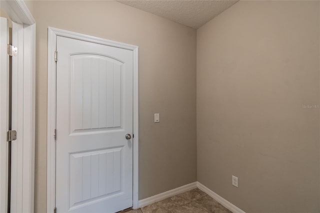 unfurnished room with light tile patterned flooring and a textured ceiling