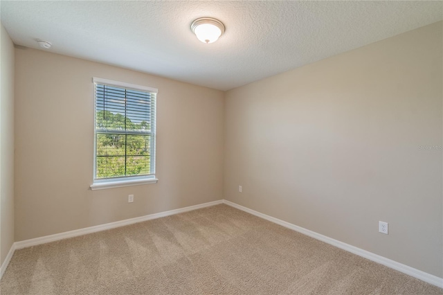 unfurnished room with a textured ceiling and carpet