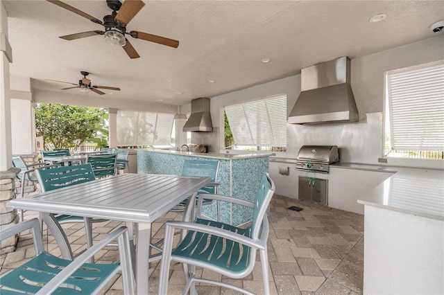 view of patio / terrace with a bar, area for grilling, and ceiling fan