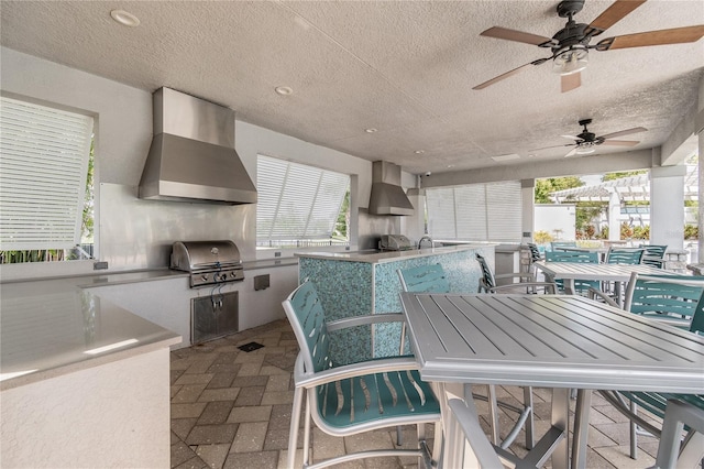 view of patio with exterior kitchen, grilling area, ceiling fan, and exterior bar