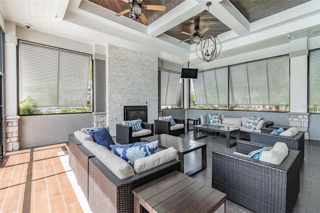 interior space with ceiling fan and an outdoor living space with a fireplace