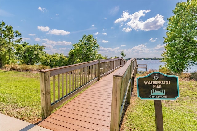 view of property's community with a lawn and a water view