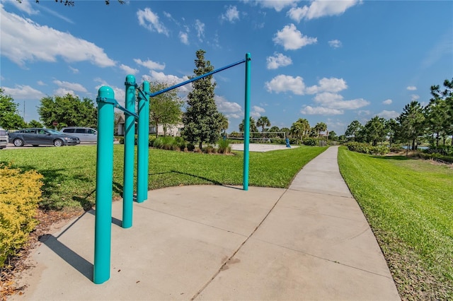 surrounding community with volleyball court and a lawn