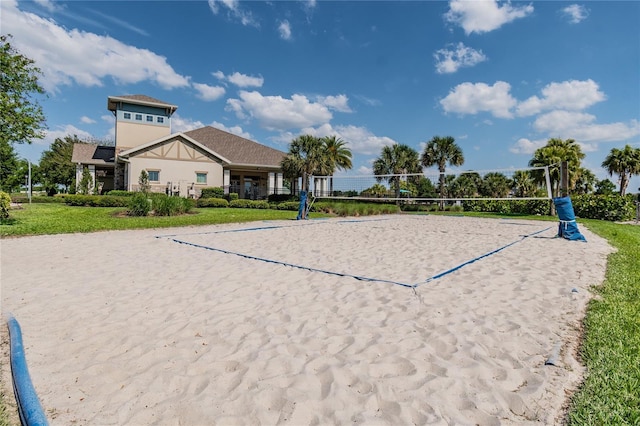 view of home's community featuring volleyball court and a lawn