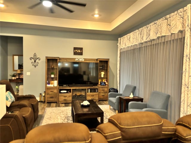 living room featuring ceiling fan and a tray ceiling