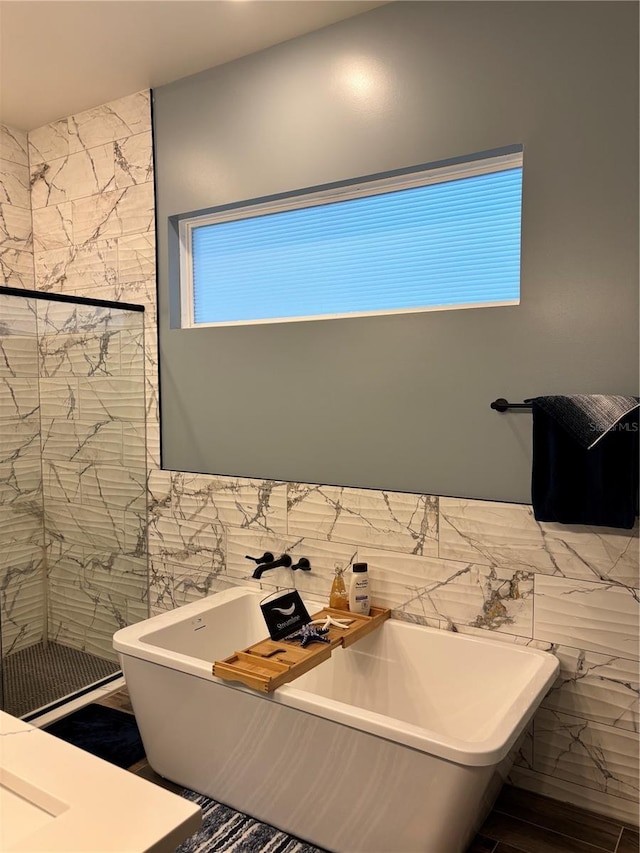 bathroom featuring a washtub and tile walls