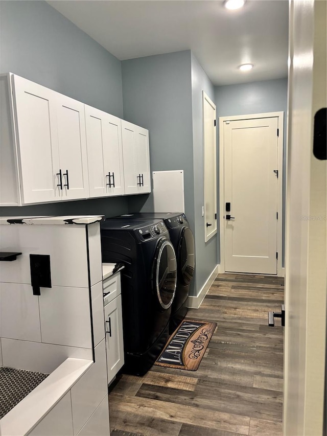 laundry area with cabinets, dark wood-type flooring, and washer and clothes dryer