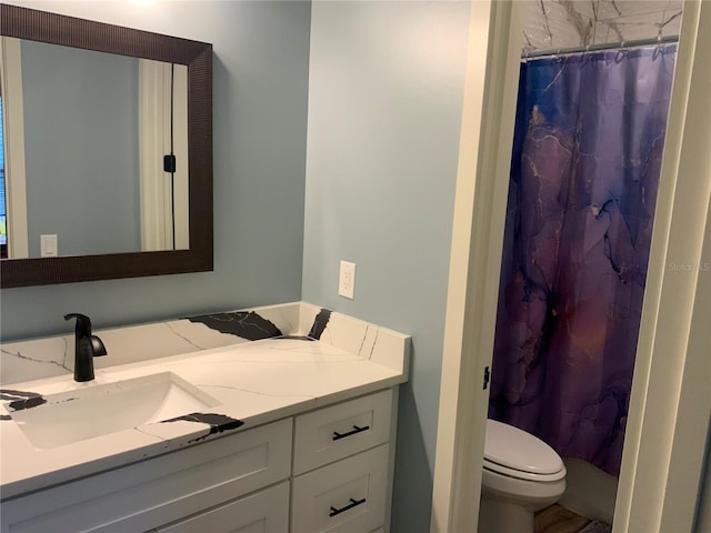 bathroom featuring curtained shower, toilet, and vanity