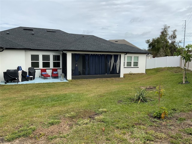 back of house with a yard and a patio