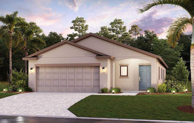 view of front of home with a yard and a garage