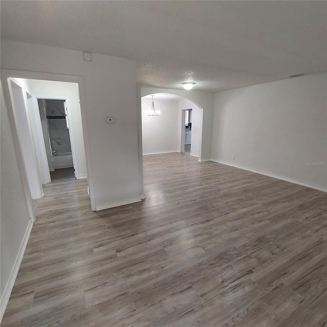 unfurnished room featuring light hardwood / wood-style flooring and a textured ceiling