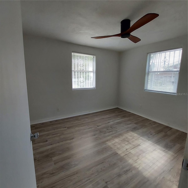 empty room with hardwood / wood-style floors and ceiling fan