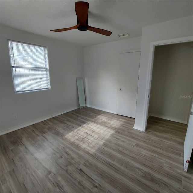 unfurnished bedroom with ceiling fan and light wood-type flooring