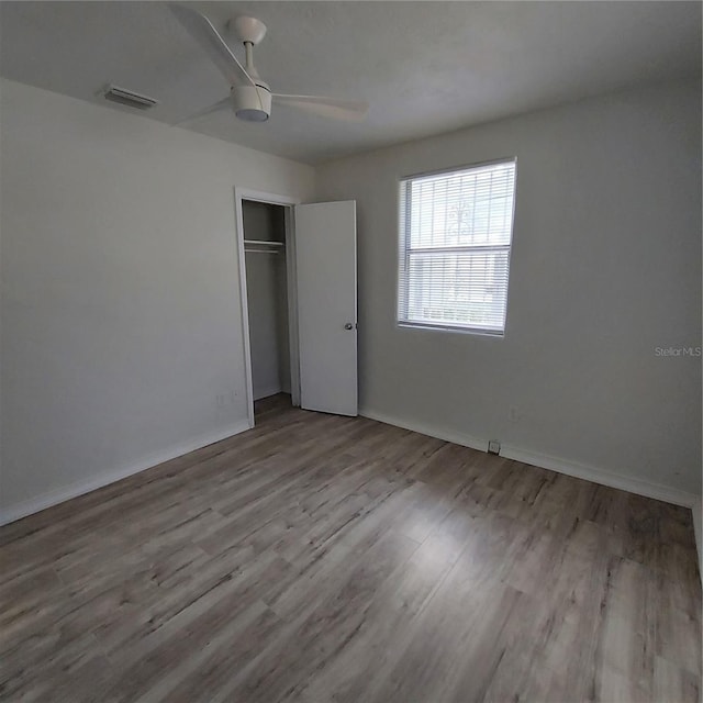 unfurnished bedroom with ceiling fan, a closet, and light hardwood / wood-style floors